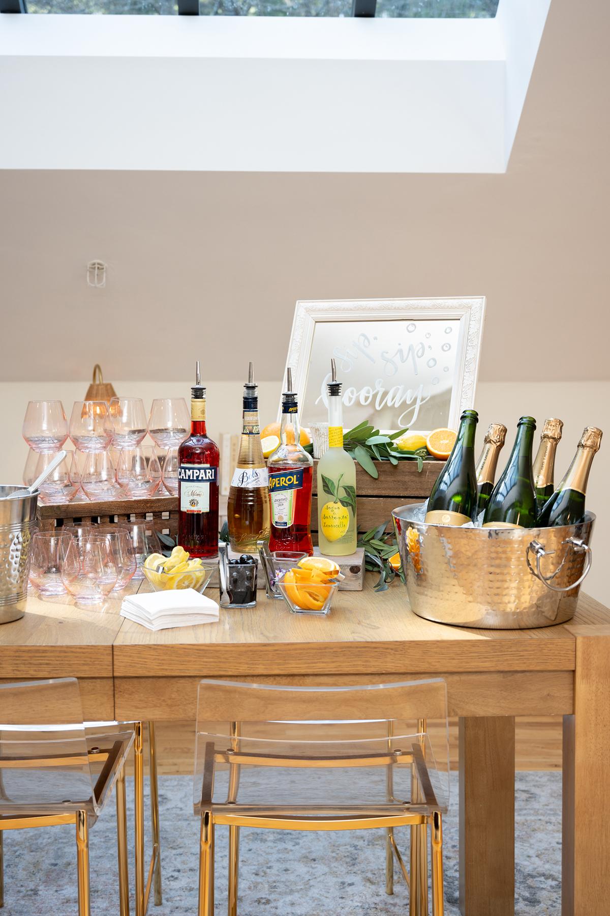 Bar setup with glasses, liquor bottles, and champagne in a metal tub.