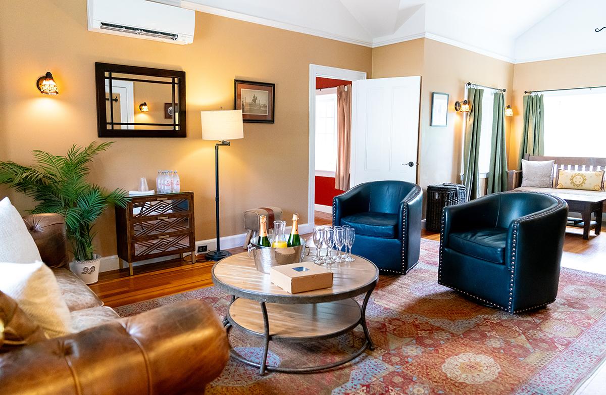Cozy living room with leather sofa, armchairs, and a round coffee table.