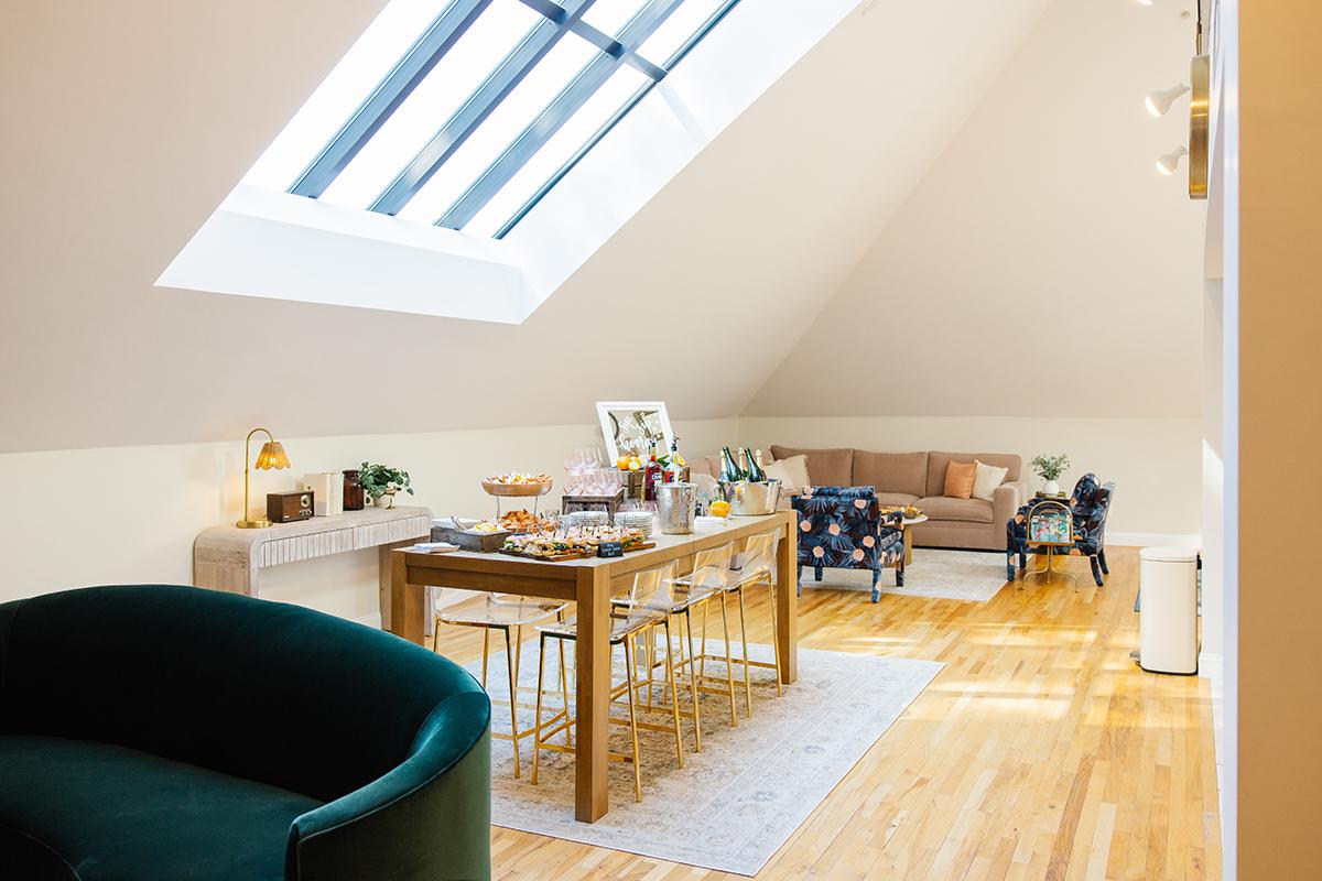 Airy loft with skylight, dining table, and cozy seating area.