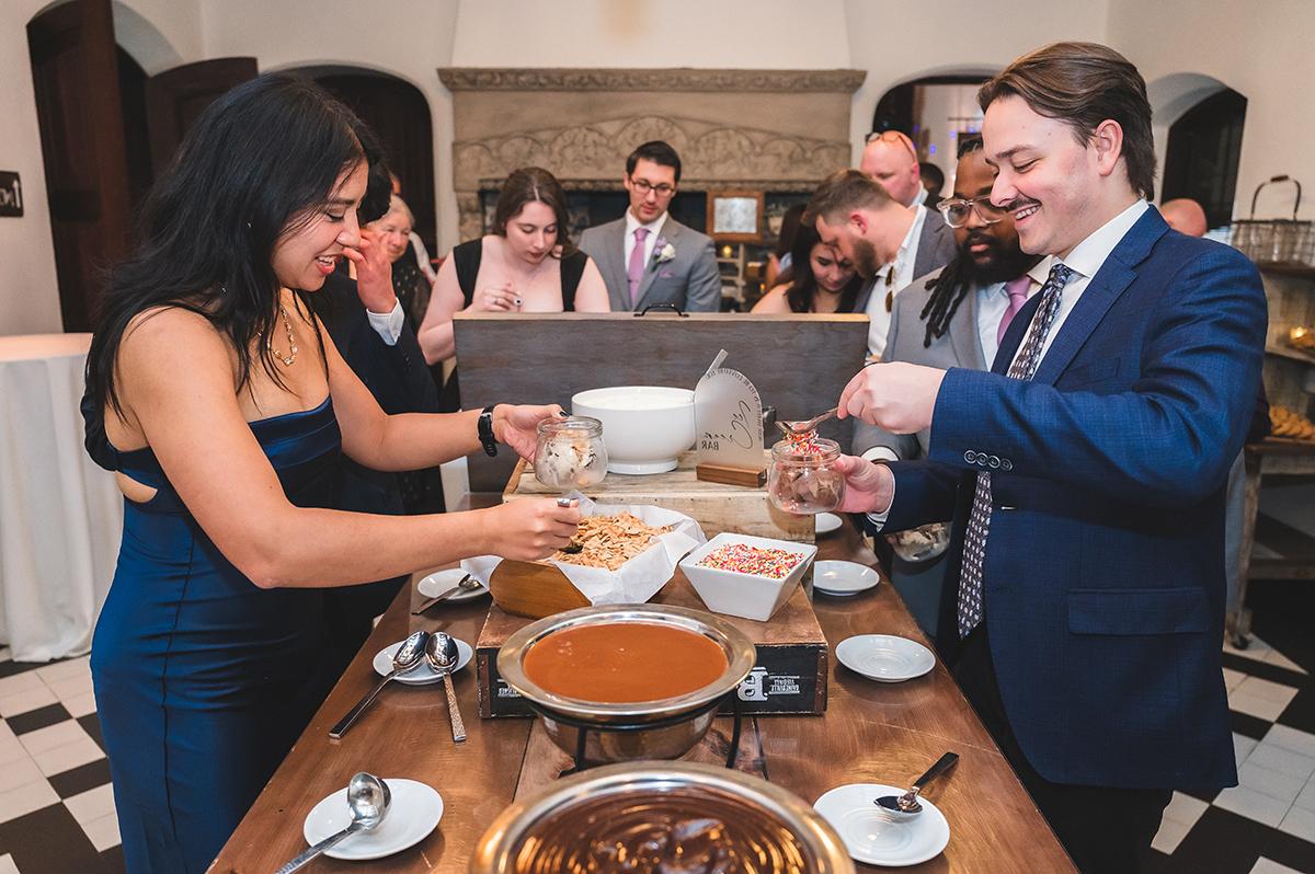 Guests serving food at a buffet table during a social gathering.