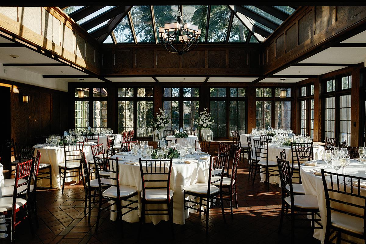 Elegant dining room with round tables and abundant natural light.