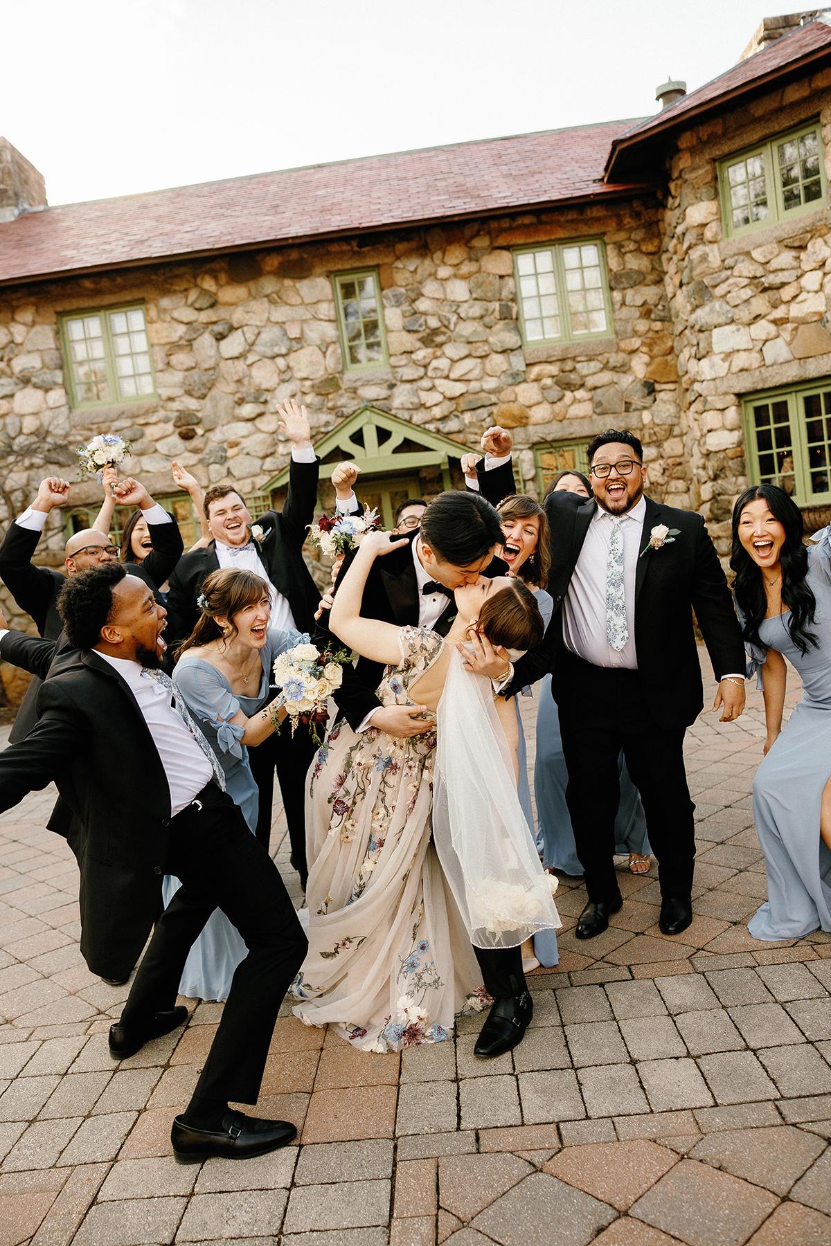 Wedding party celebrating outdoors with laughter and cheers.