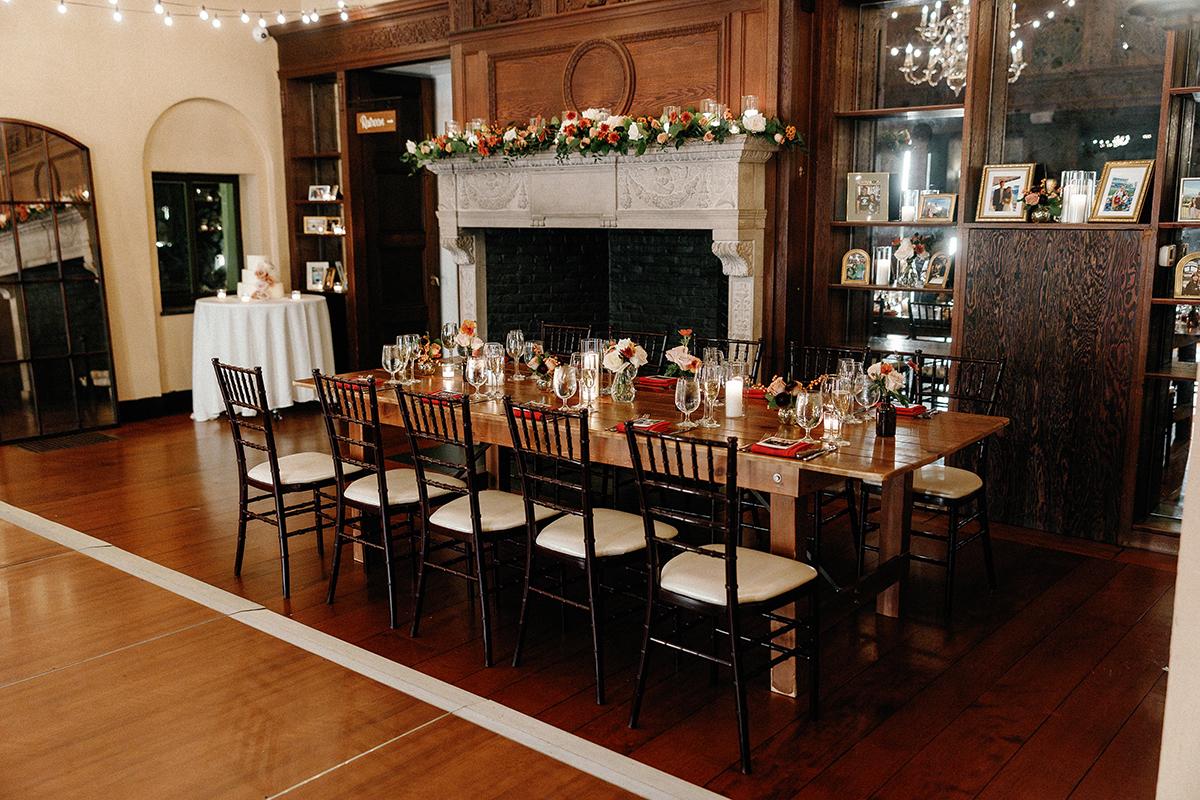 Dining table set for a formal dinner in an elegant room with a fireplace.