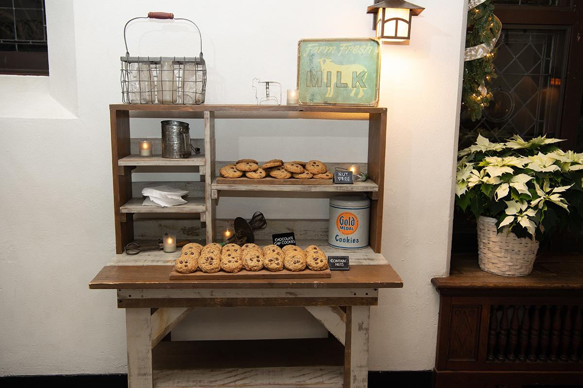 Rustic cookie display on a wooden table with potted poinsettia nearby.