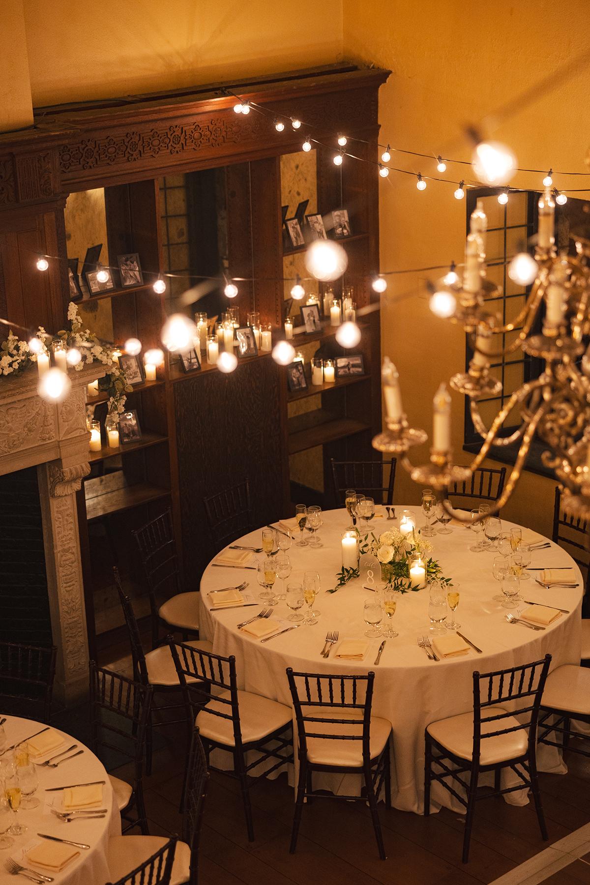 Elegant dining room with round table and warm string lights.