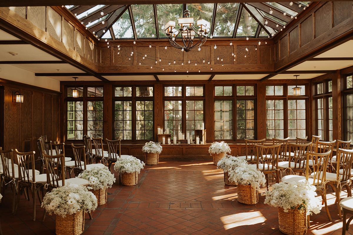 Sunlit wedding venue with chairs and flower decorations.