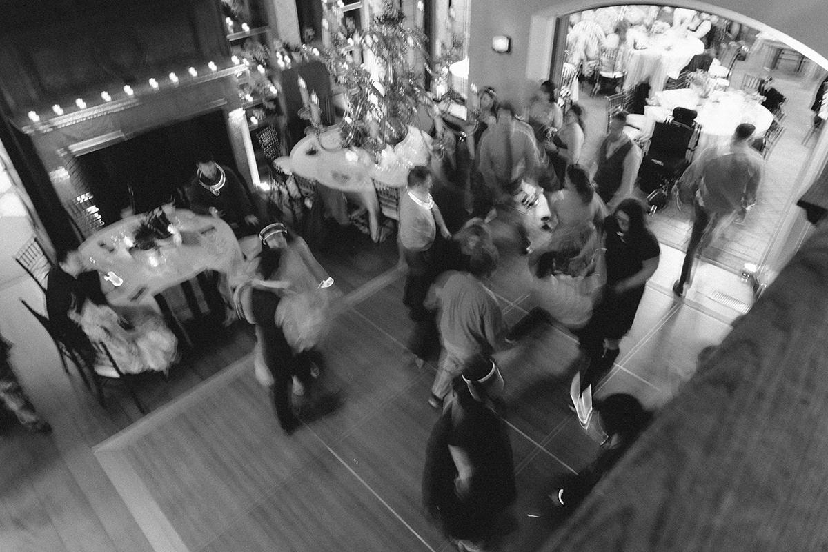 Black and white photo of a lively indoor party with people dancing.