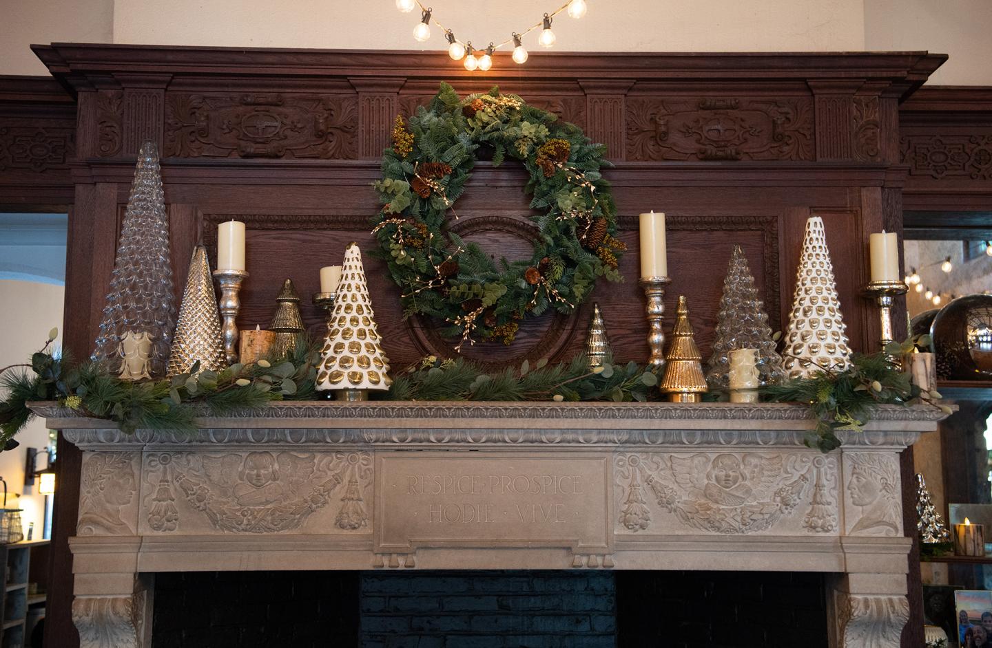 Festive mantel with wreath, garland, candles, and miniature Christmas trees